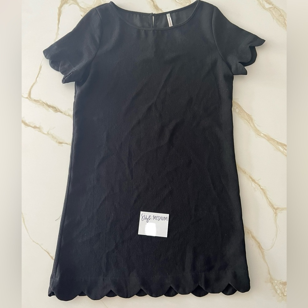 Size Medium black dress for sale. Scalloped sleeves & hem. Good condition.